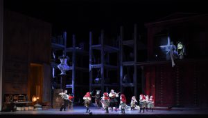 Un théâtre de marionnettes, un fauteuil à bascule et des cubes ont été déposés dans un coin de la scène, en des réminiscences de l’enfance, tandis qu’un livre de contes de Grimm se trouve à l’autre extrémité.