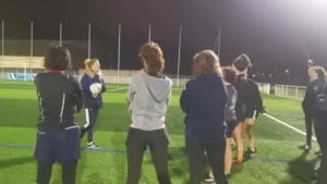 Amandine (avec le ballon) donnant des instructions à l'équipe lors d'un entraînement