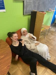 Deux jeunes filles qui sourient et prennent la pose pendant les ateliers de préparation de la performance d'éloquence organisée par place aux jeunes