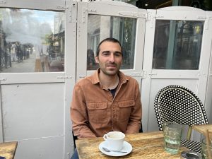 Pierre assis dans un café, comme à son habitude.
