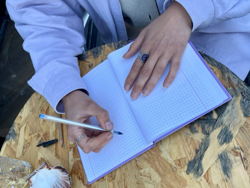 carnet avec une main tenant un stylo