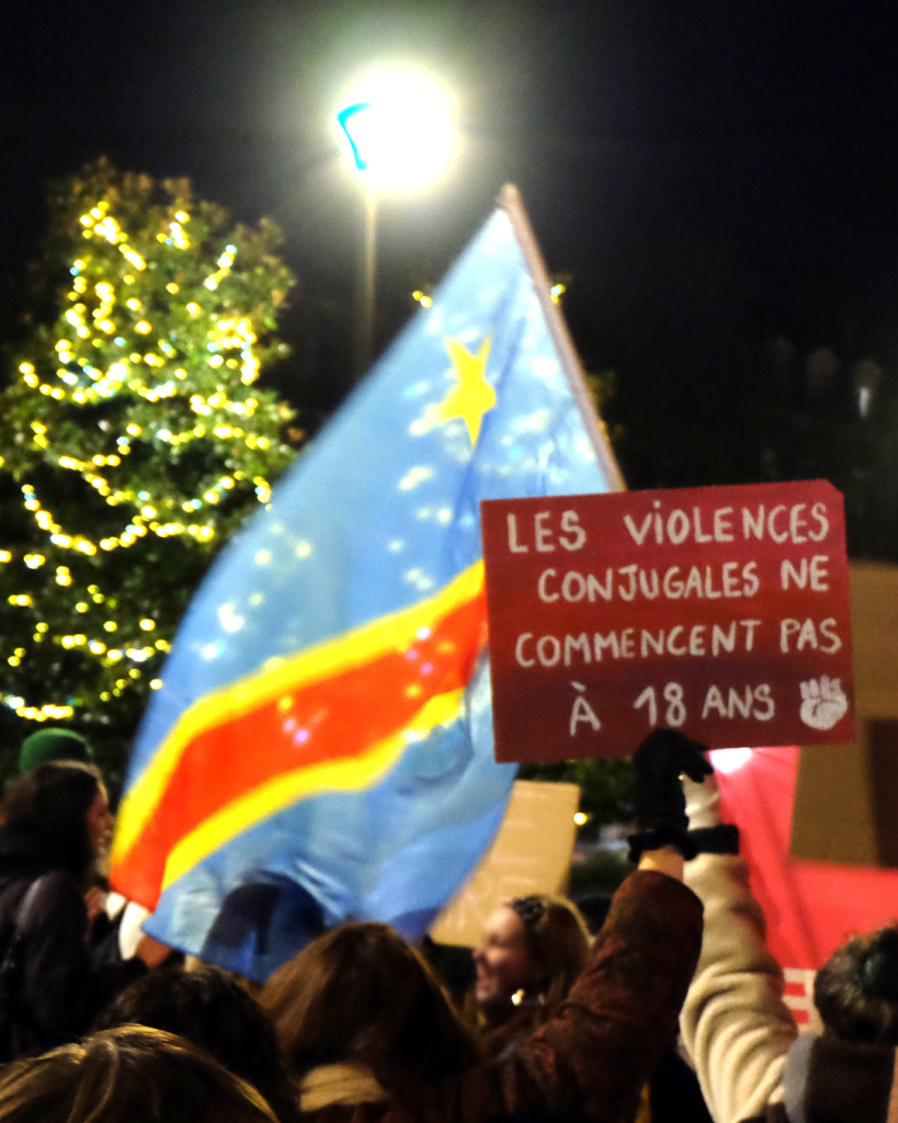 Le drapeau du Congo flottait sur le cortège. En effet, les organisateurices de la manifestation en ont fait un moment de lutte internationale en donnant la parole à XXX qui a rappelé que les violences sexistes et sexuelles et en particulier le viol sont une arme de guerre actuellement utilisée au Congo. 25/11/2025 © Amandine Masson
