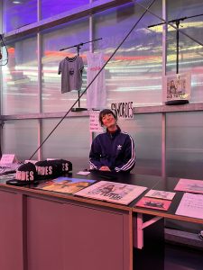 Zoé travaille à Stereolux en alternance et fait partie du pôle communication. Ce mardi, elle est venue tenir le merch de l'artiste américaine Swordes à la demande de Stereolux car la chanteuse ne pouvait pas l'assurer. "D’en plus tenir le merch de soirées comme ça, ça a du sens" explique Zoé. "J'étais à une table ronde qui avait lieu sur Twitch avant le concert et que portait sur la place de la femme dans le milieu musical. J'étais en réalisation, avec les caméras", souligne t-elle en expliquant son engagement dans la soirée. Date : 18/11/2025 Crédit photo : Lou Defois